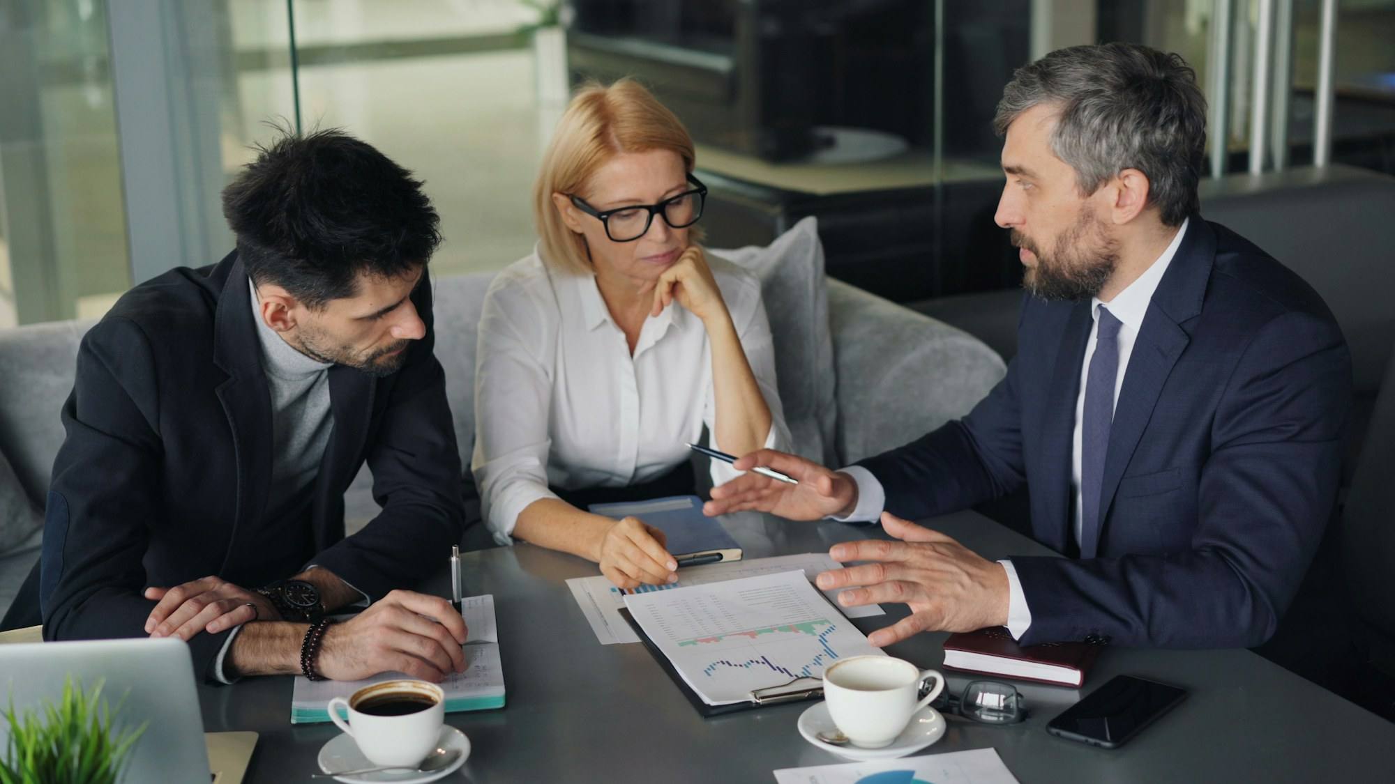 Three people reviewing a company’s accounts at a table