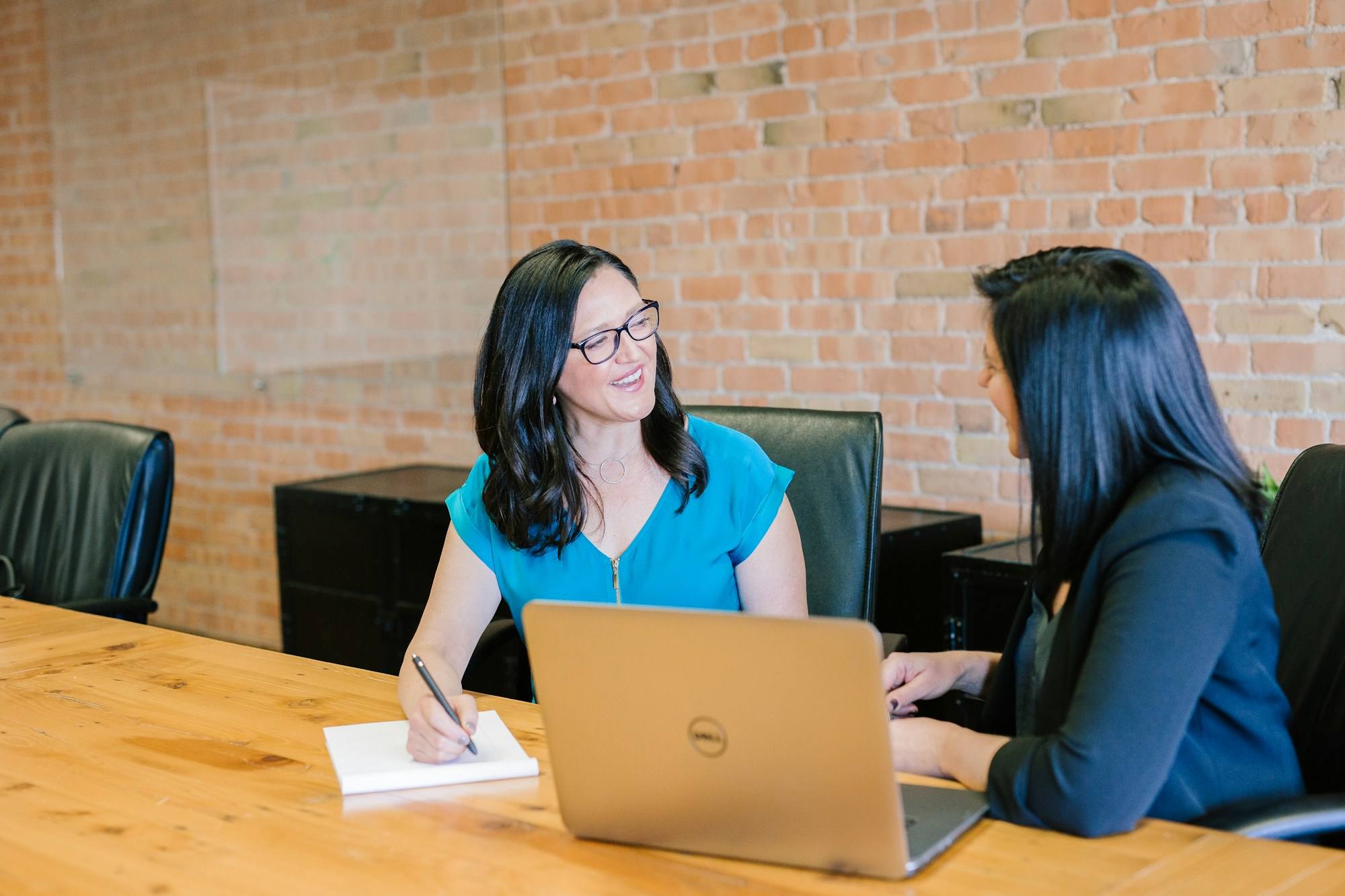 A bookkeeper with a laptop and notes talking with a client
