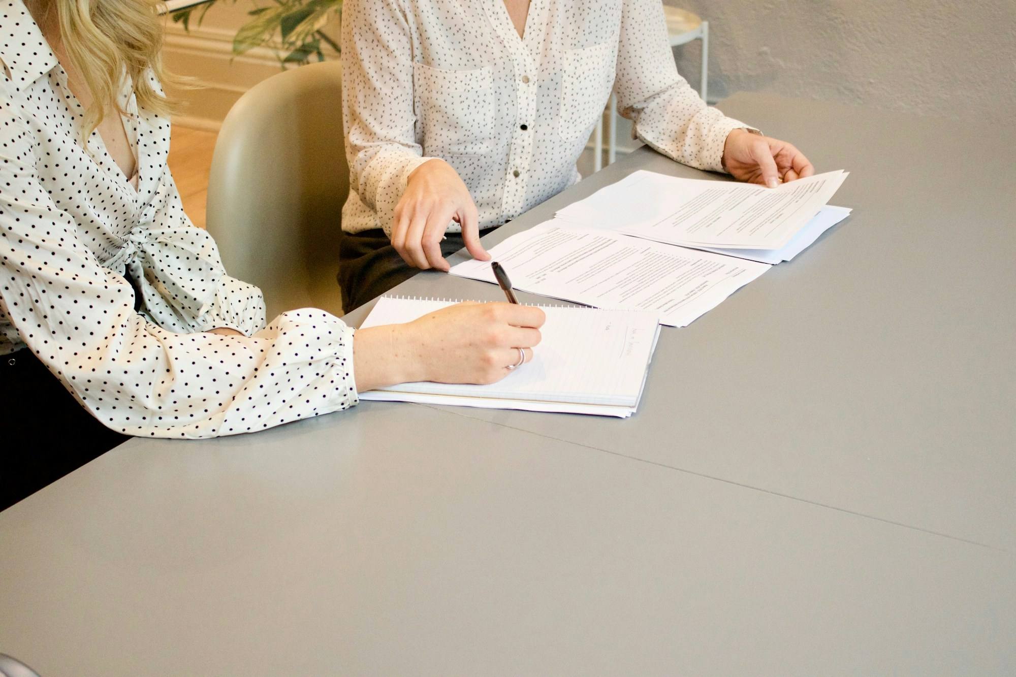 A client signing paperwork beside her adviser